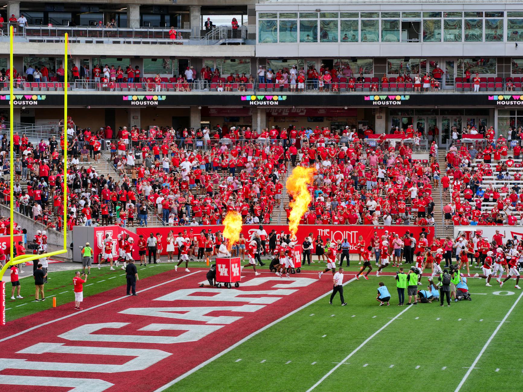 Houston college football match with vibrant crowd and fire effects. Captures the sports spirit.