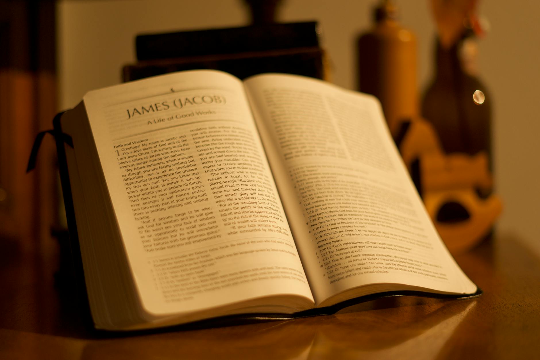 Open Bible displaying the Book of James in warm ambient lighting on a wooden table.