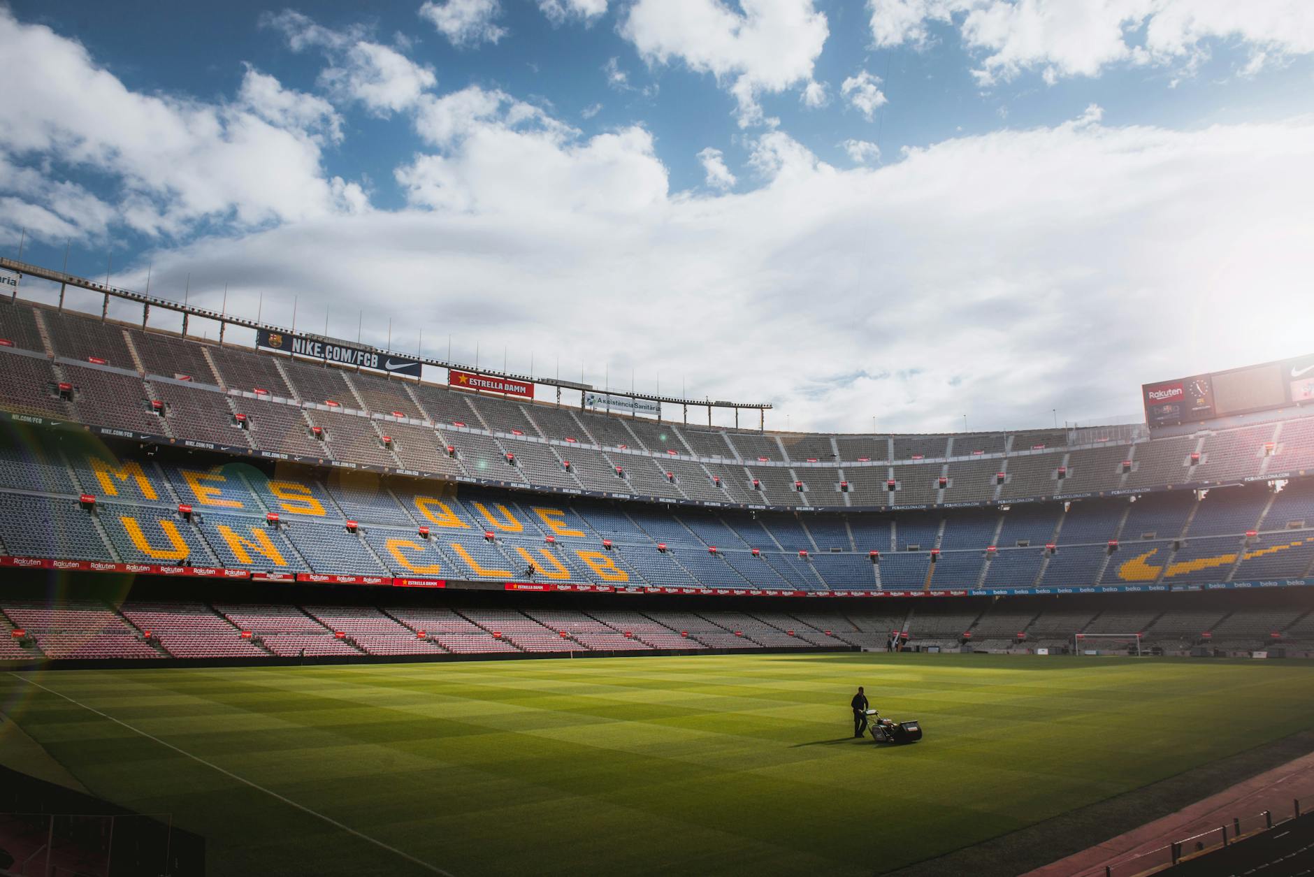 A vibrant football stadium with a well-maintained grass field under a bright sky, showcasing its iconic architecture.