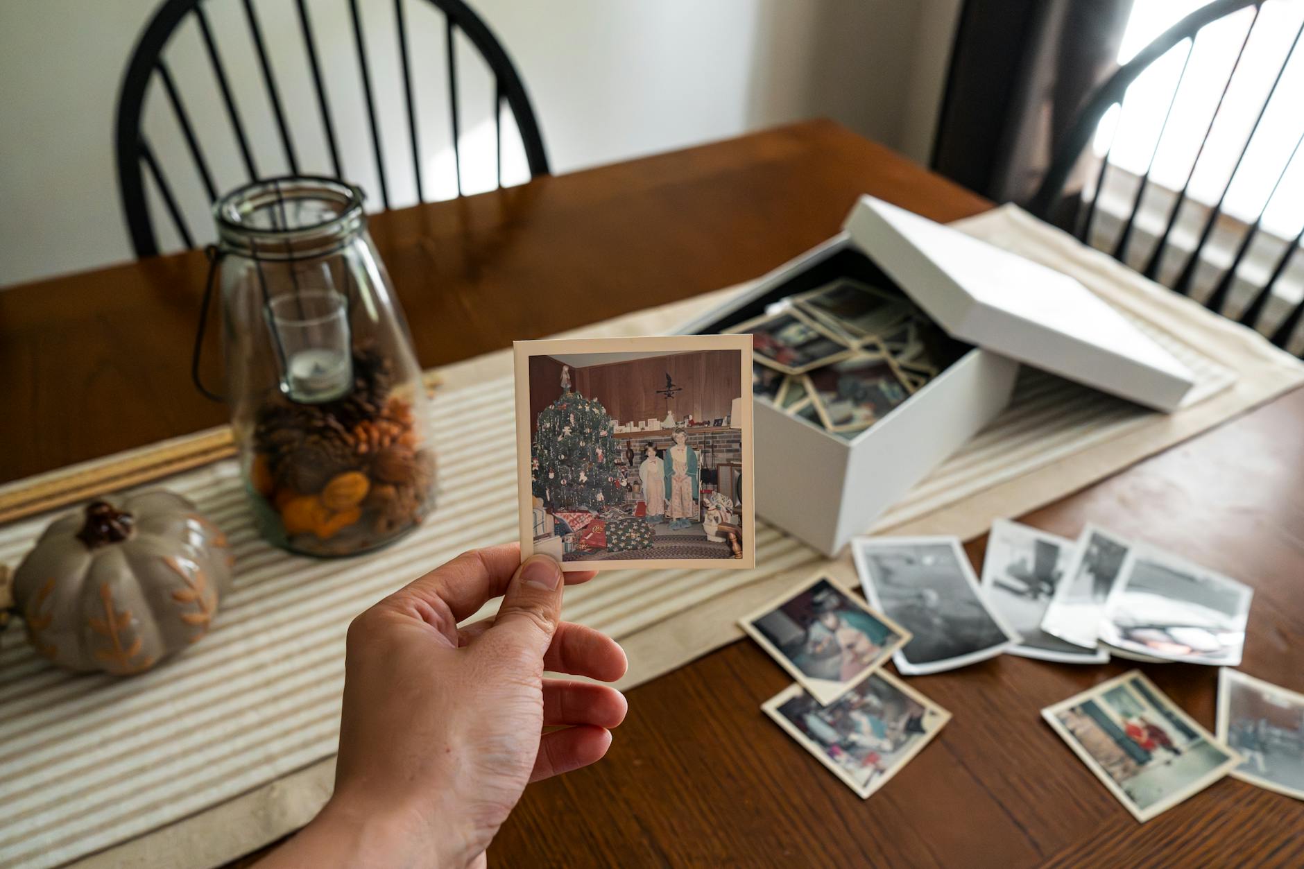 A nostalgic collection of vintage family photos displayed on a wooden table.