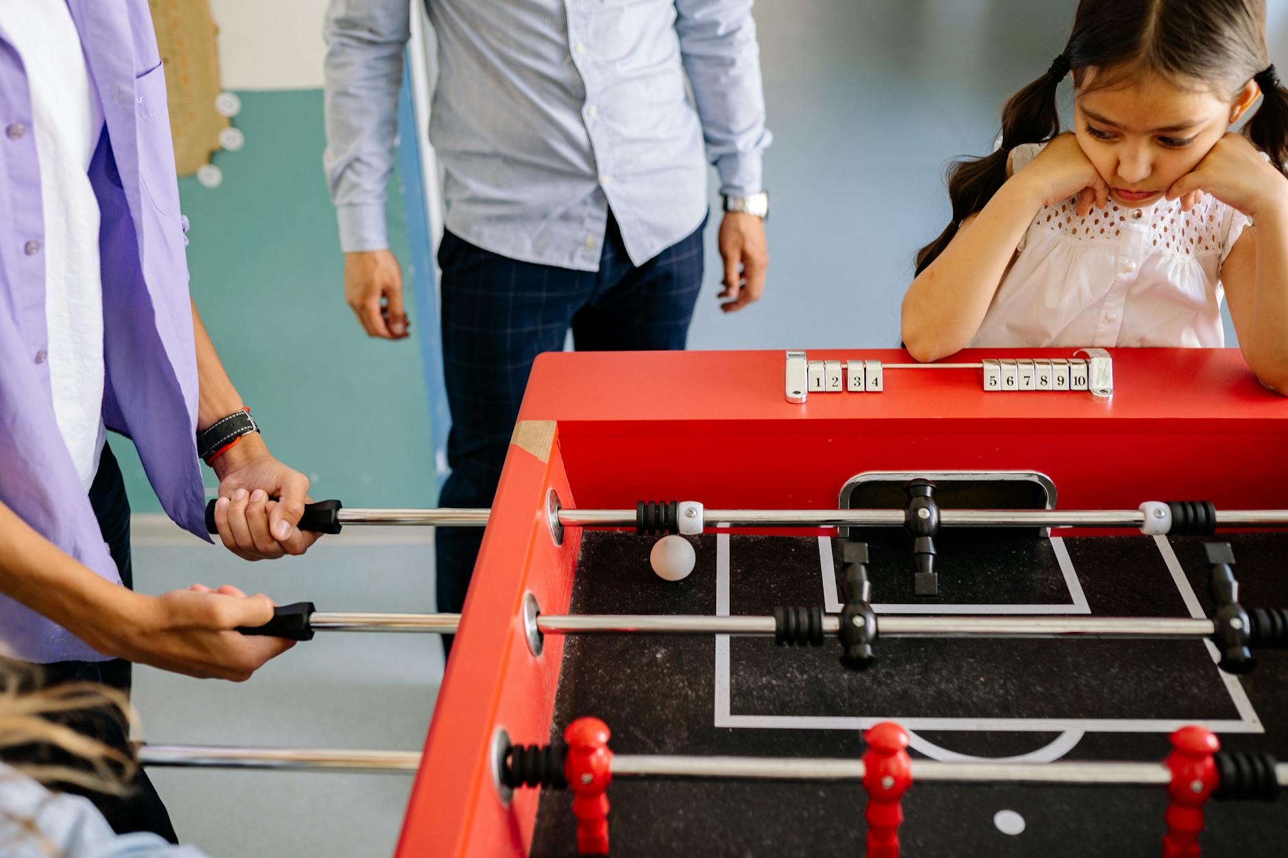 Kids playing foosball indoors, capturing playful interaction and teamwork among students.