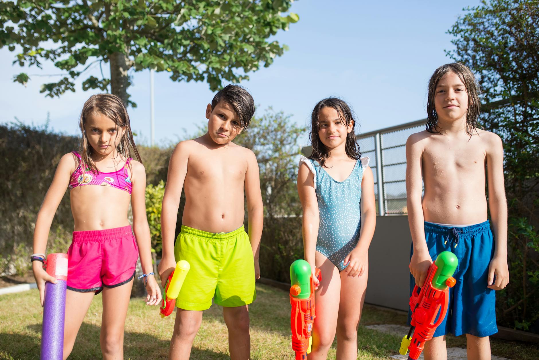 Children having fun with water guns outdoors in sunny Portugal. Summer fun and playtime.