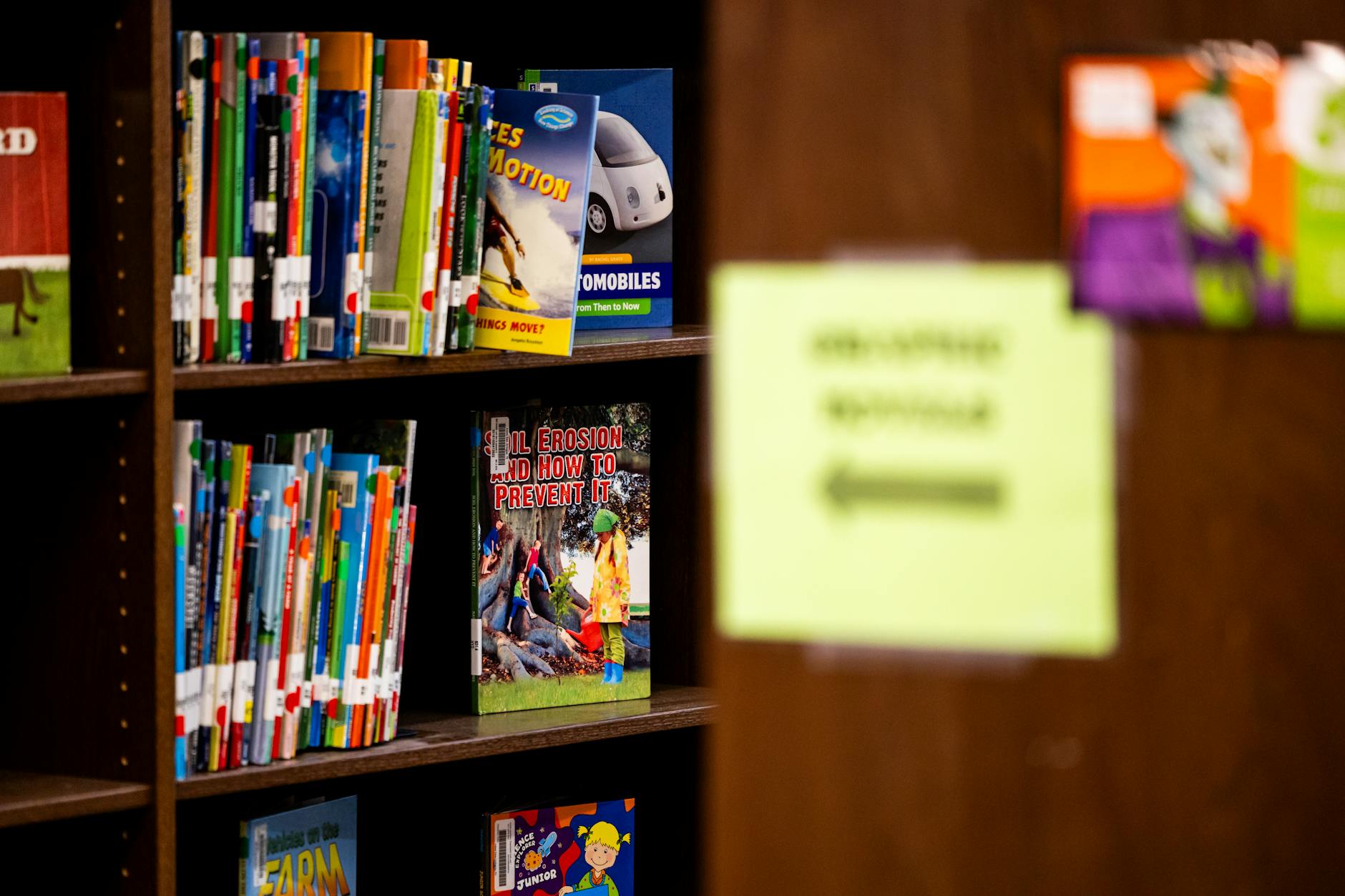 A library shelf filled with colorful children's books, focused on educational topics.