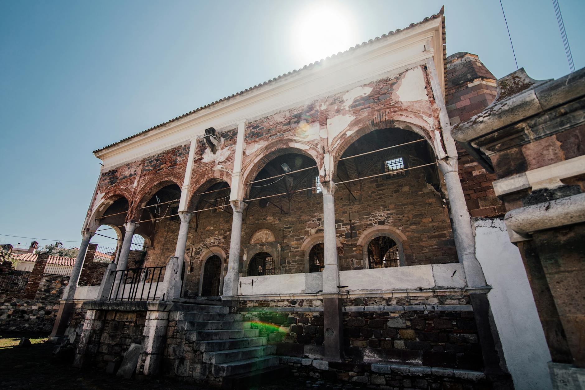 Explore the ancient ruins of a historic mosque, showcasing classic architecture under bright sunlight.