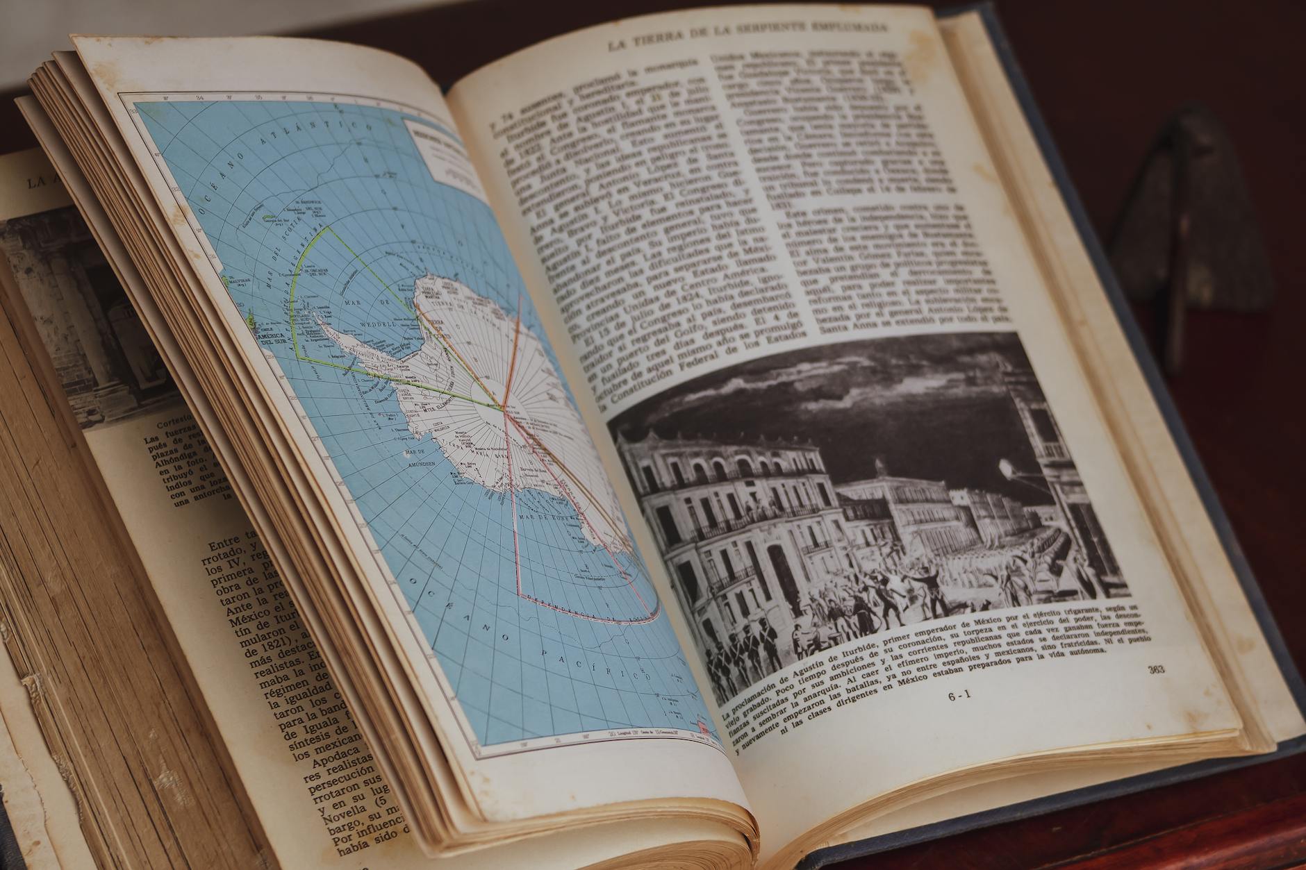 Detailed close-up of an open history book showing a vintage map and illustration.